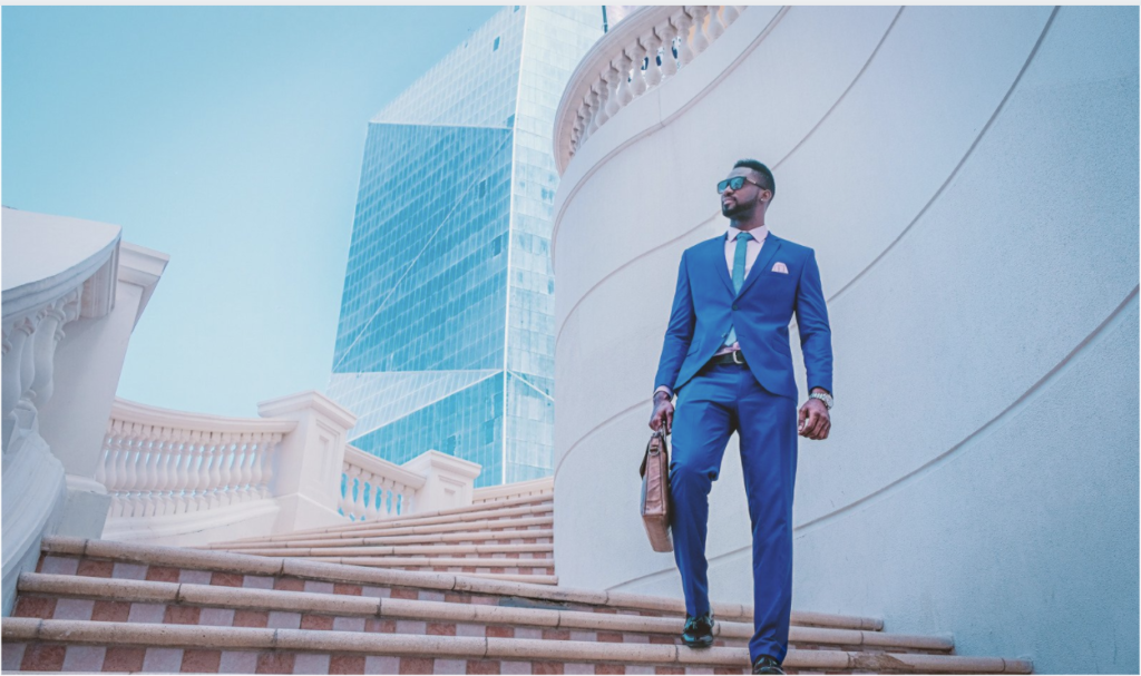 African American business man on a city background colored image for The ten Things CMOs Need From The VP of Sales blog post for apex cmo search