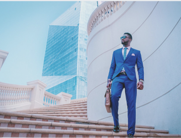 African American business man on a city background colored image for The ten Things CMOs Need From The VP of Sales blog post for apex cmo search